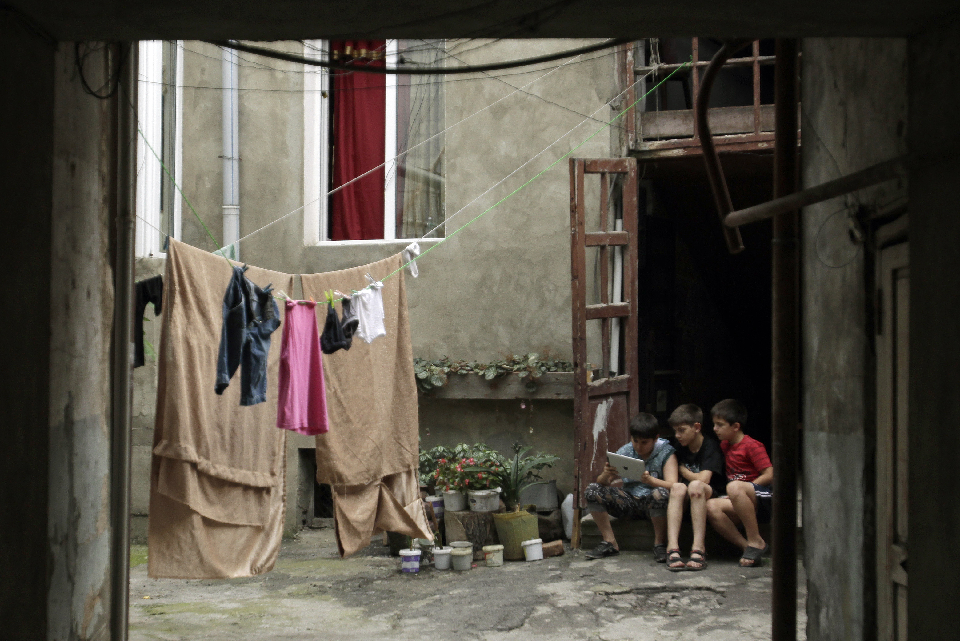 Дети c айпадом в одном из тбилисских дворов. Фото: REUTERS/Давид Мдзинаришвили. Дети и интернет