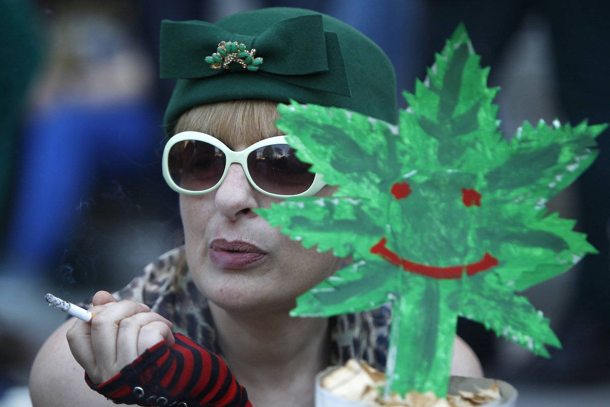 Употребление конопли в Грузии легально. Женщина курит сигарету на акции, посвященной легализации марихуаны. Тбилиси, 2 июня, 2013 год. REUTERS/Давид Мдзинаришвили