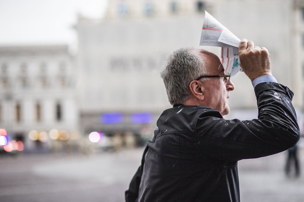 Man on the street with a brochureმამაკაცი კუჩაში ბროშურით