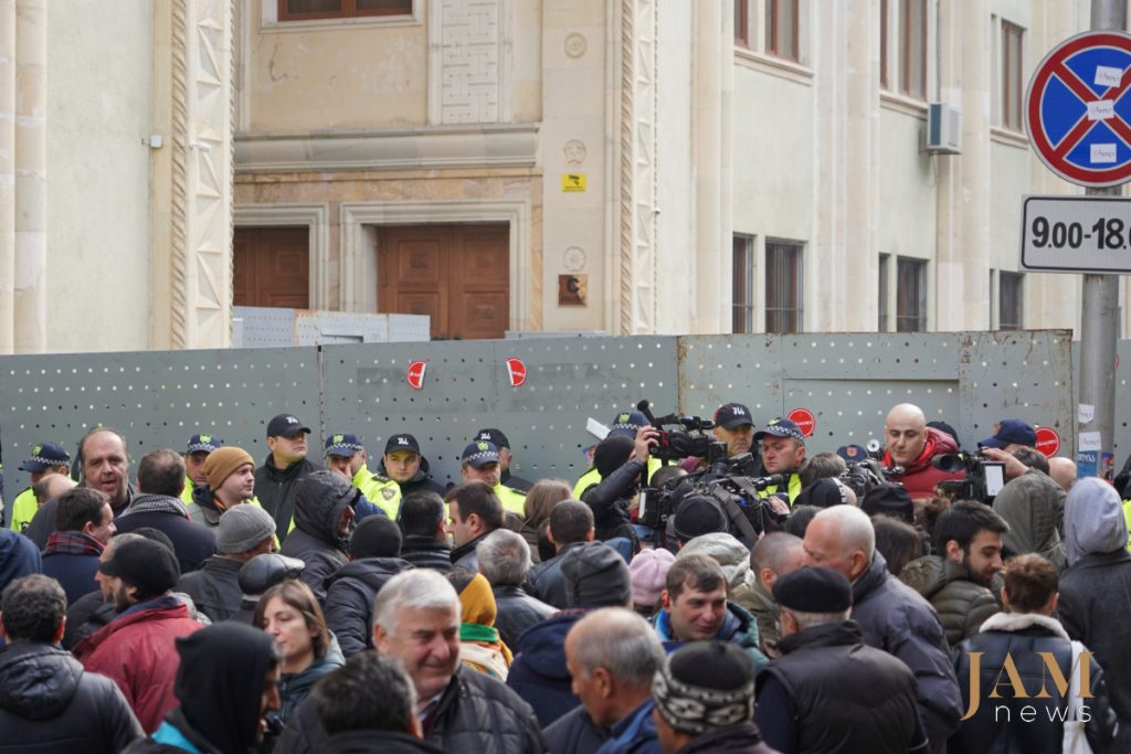 Митингующие и полицейские возле здания парламента აქციის მონაწილეები და პოლიციელები პარლამენტის რკინის მესერთან