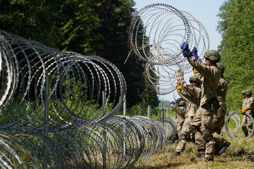 Солдаты литовской армии устанавливают колючую проволоку на границе с Беларусью в Друскининкае, Литва, 9 июля 2021 года. REUTERS/Janis Laizans 