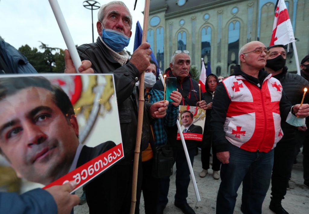  Люди протестуют перед зданием парламента в Тбилиси, требуя освобождения бывшего президента Грузии Михаила Саакашвили. 10 октября 2021 г. REUTERS / Ираклий Геденидзе