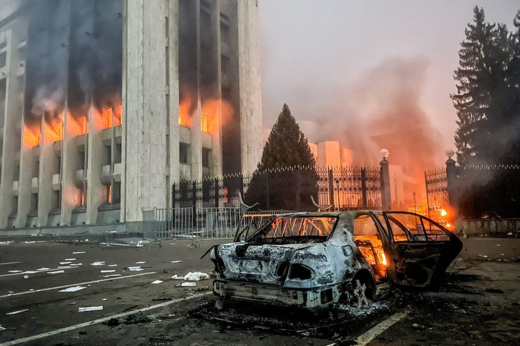 Сгоревшая машина у здания мэрии Алматы. Фото Valery Sharifulin/TASS. Как Россия использует столкновения в Казахстане