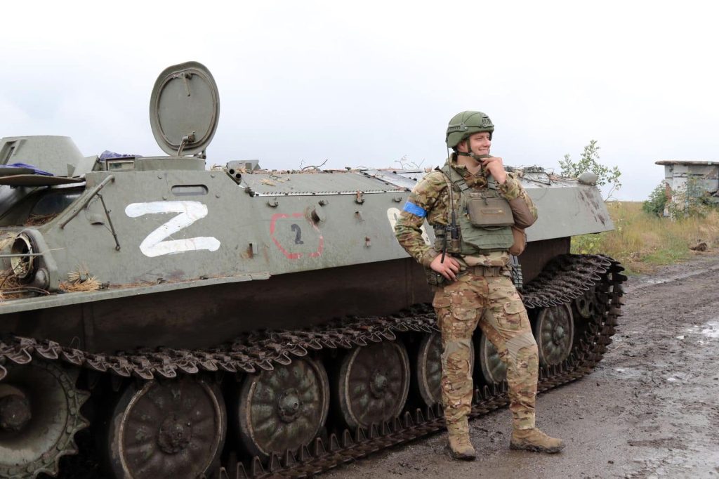 Украинский военнослужащий на фоне трофейного российского бронетранспортера. Фото: министерство обороны Украины 
