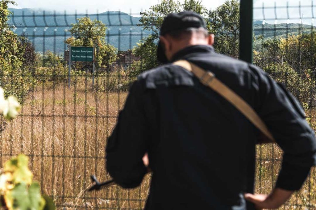 A Georgian military police officer stands at the line of separation with South Ossetia. Beyond the fence, a sign warns about crossing into South Ossetia. CRISIS GROUP/ Jorge Gutierrez Lucena