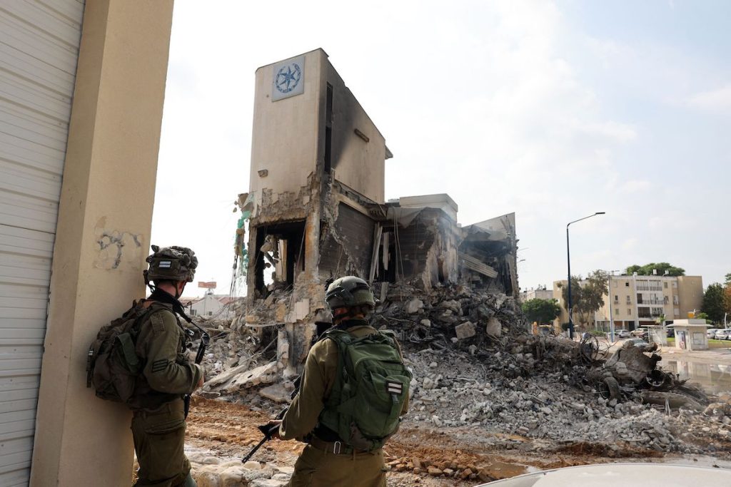 Солдаты стоят перед полицейским участком в Израиле, который был уничтожен, чтобы вытеснить находящихся внутри боевиков ХАМАС. 8 октября, 2023. JACK GUEZ/AFP