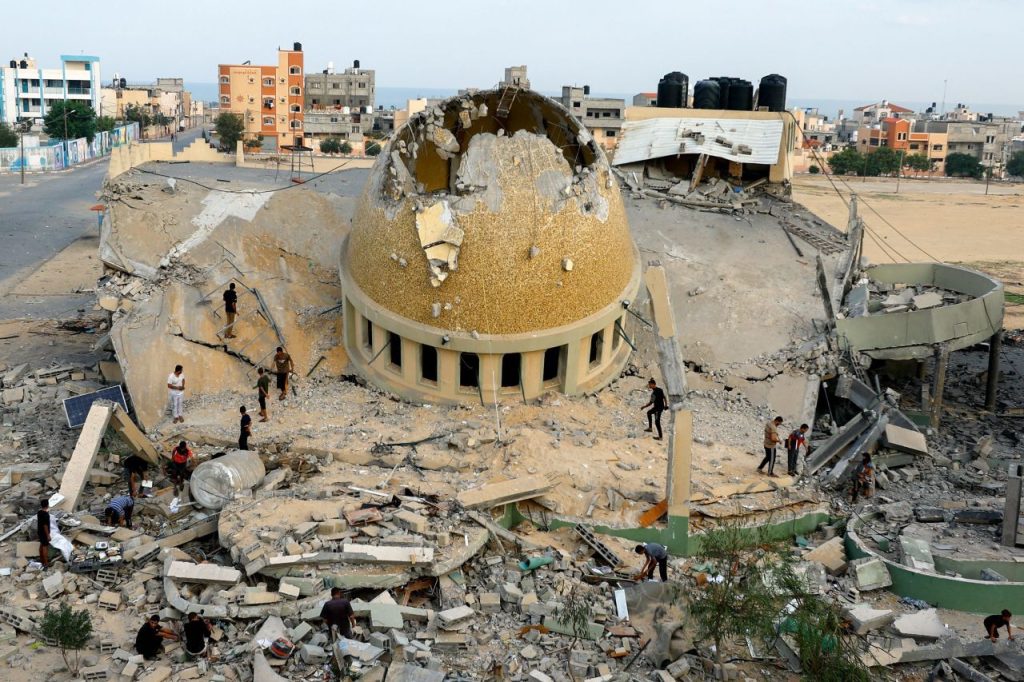 Палестинцы осматривают мечеть, разрушенную в результате авиаударов Израиля, в Хан-Юнисе, сектор Газа. 8 октября, 2023. Ibraheem Abu Mustafa/Reuters