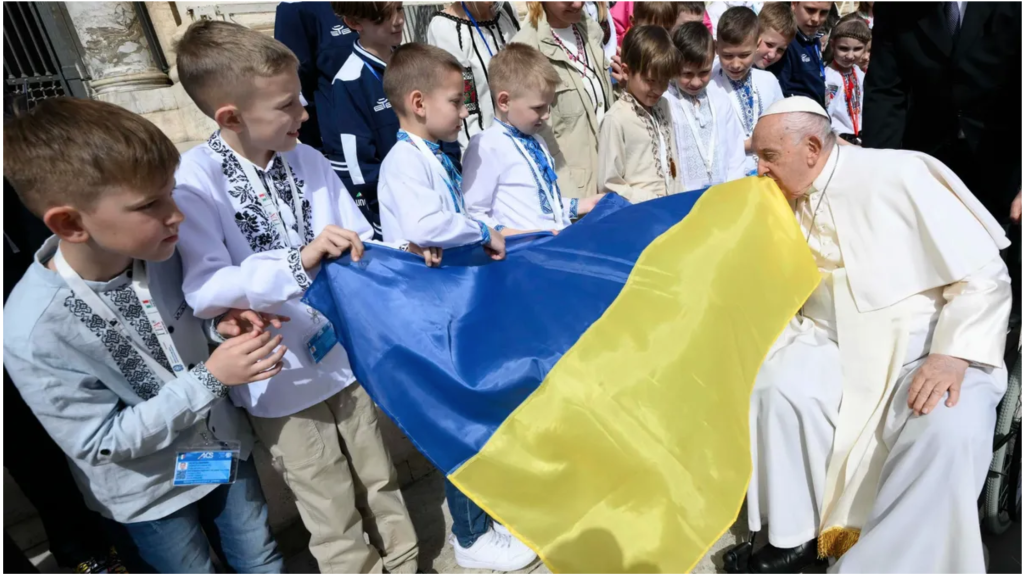 Pope Francis kisses a Ukrainian flag carried by a group of Ukrainian children attending his weekly general audience in St. Peter’s Square at the Vatican April 10, 2024. The pope prayed during the audience for peace in Ukraine, in the Holy Land and in Myanmar. (CNS photo/Vatican Media) Pope and the war in Ukraine  